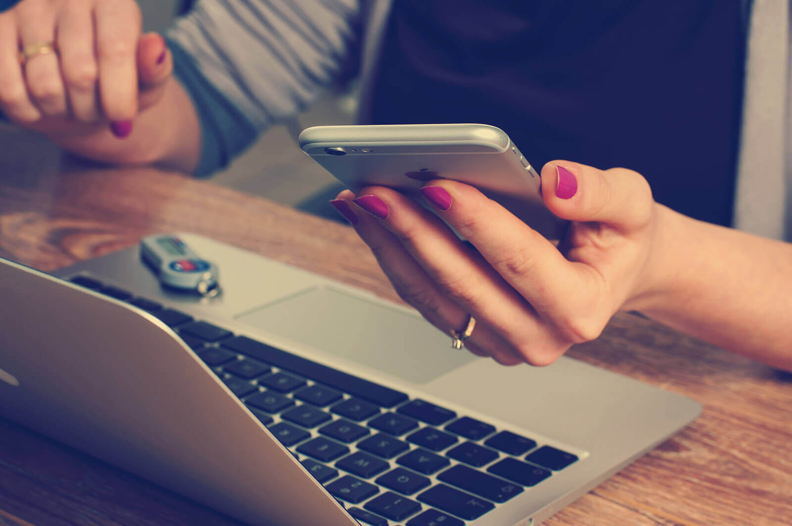 Woman on computer and holding phone