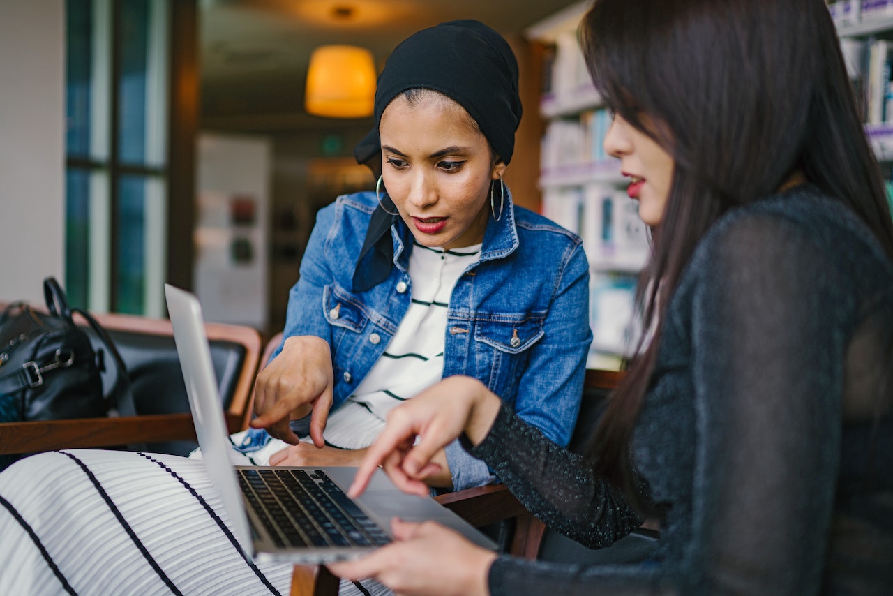 Employees reading together on a laptop