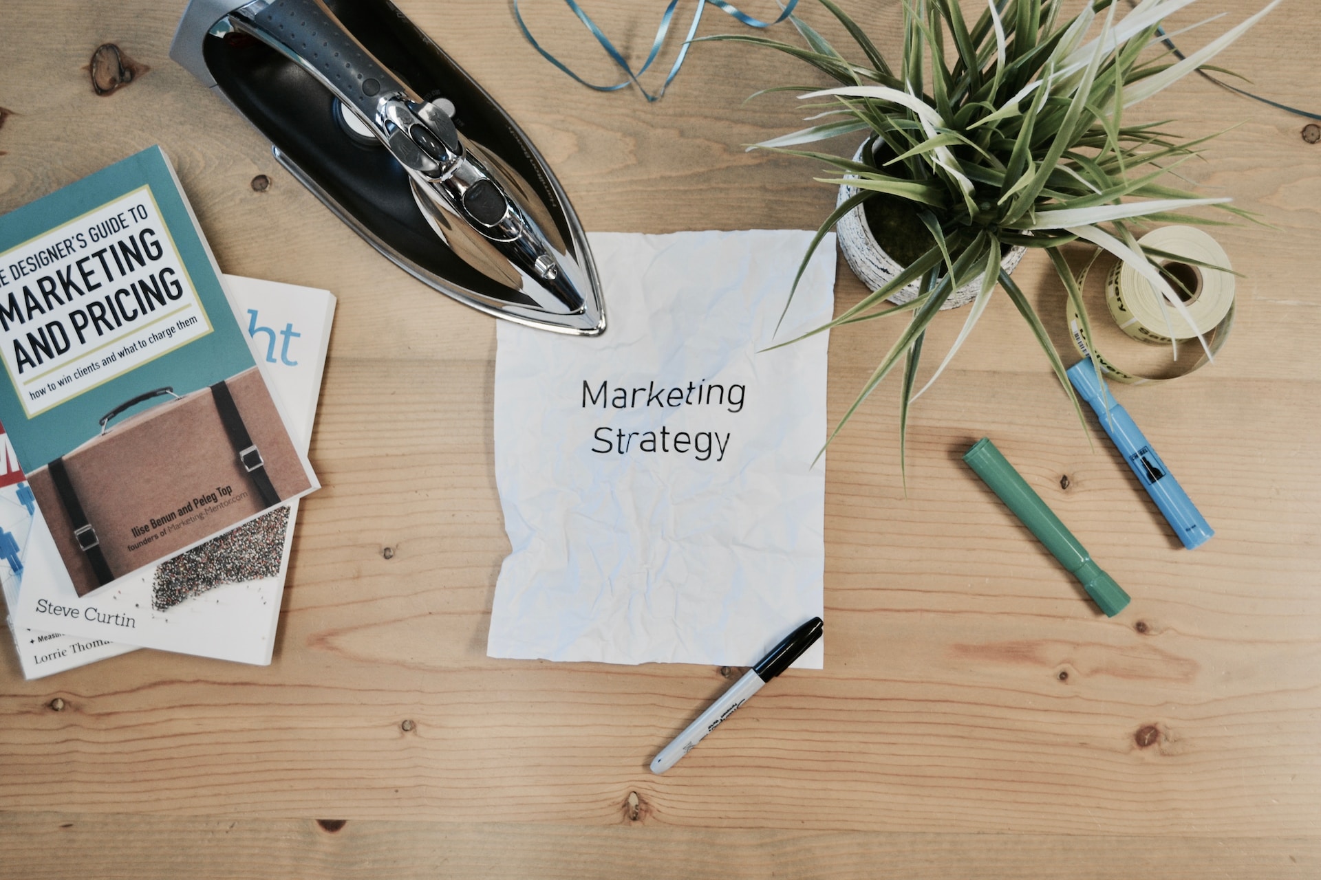 Overhead shot of a table with an iron and a wrinkled Marketing Strategy page