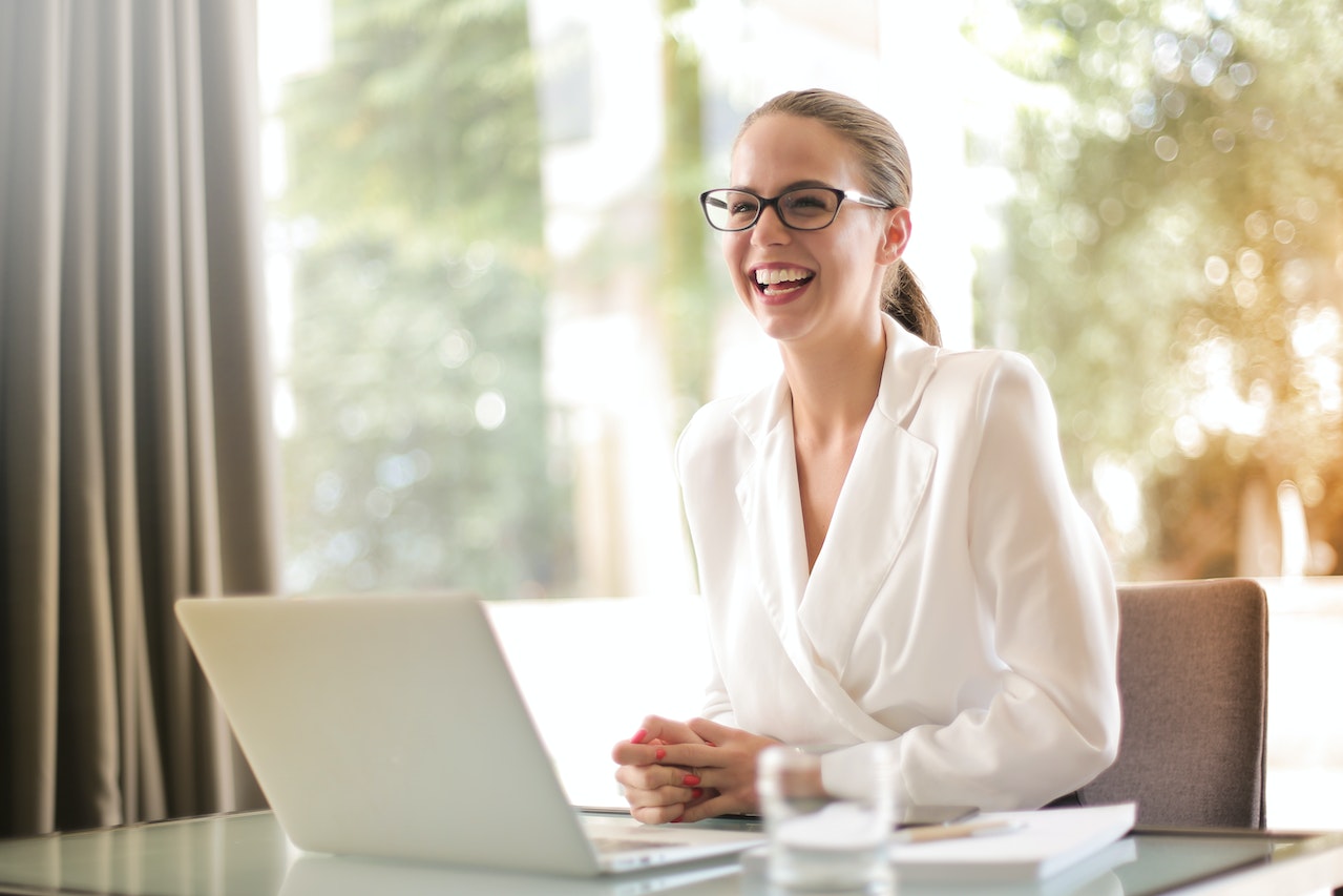 laughing-businesswoman-working-in-office-with-laptop